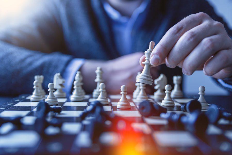 close up of man playing chess an moving a piece with his hand 2