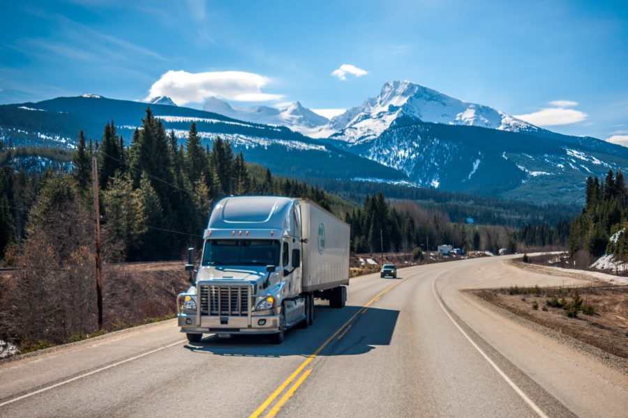 Front view of truck driving on road with mountains in the background 2