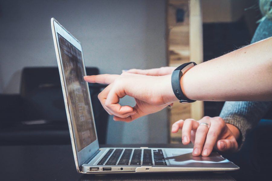 two hands pointing at laptop screen