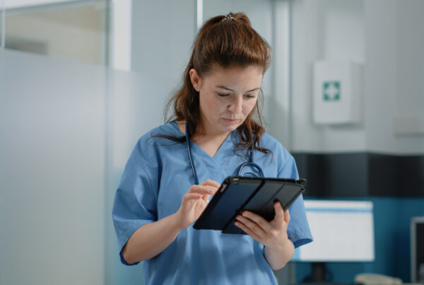 Caucasian nurse using digital tablet with touch screen