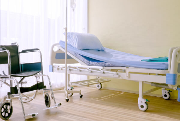 Hospital bed and wheelchair at hospital room.
