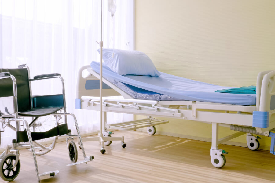 Hospital bed and wheelchair at hospital room.