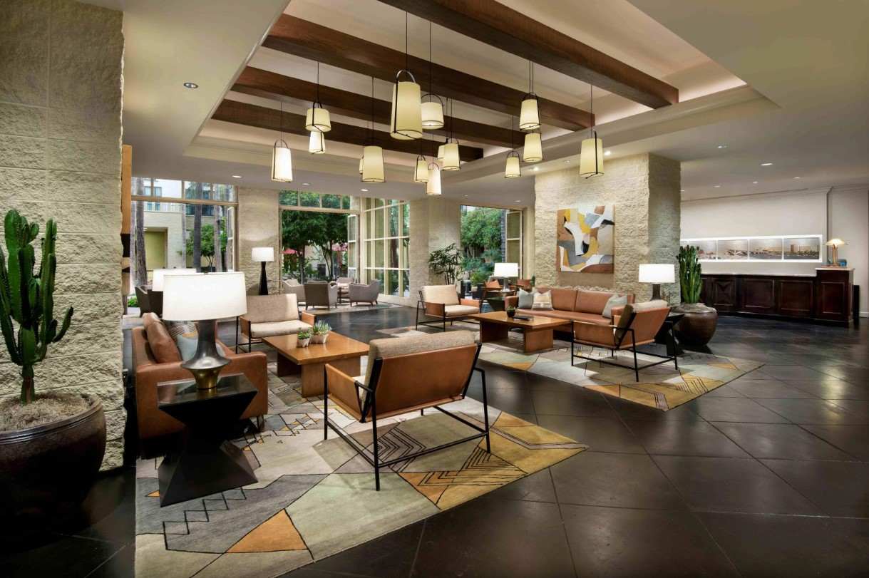 Hotel lobby with high ceiling, elegant decor, and comfortable seating area