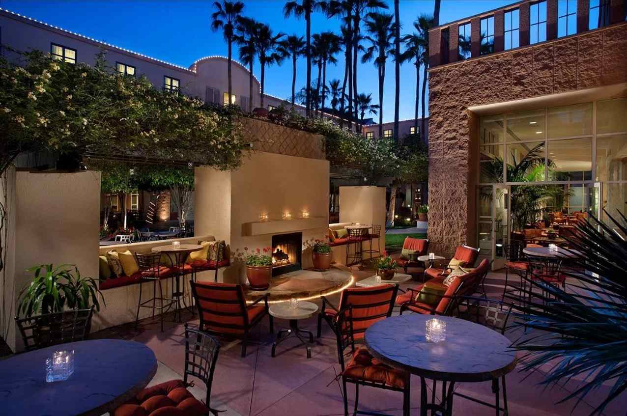 An outdoor hotel patio in the evening with a fireplace