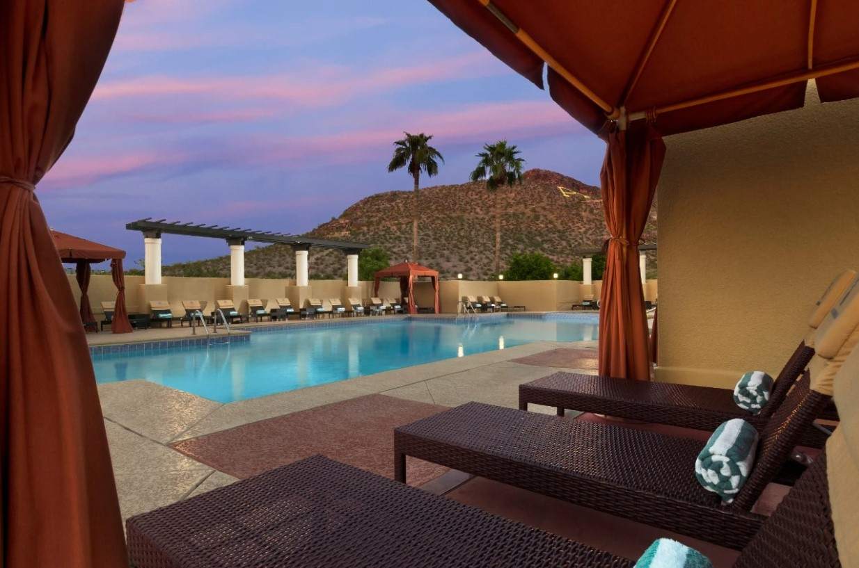 A resort pool surrounded by comfortable lounge chairs