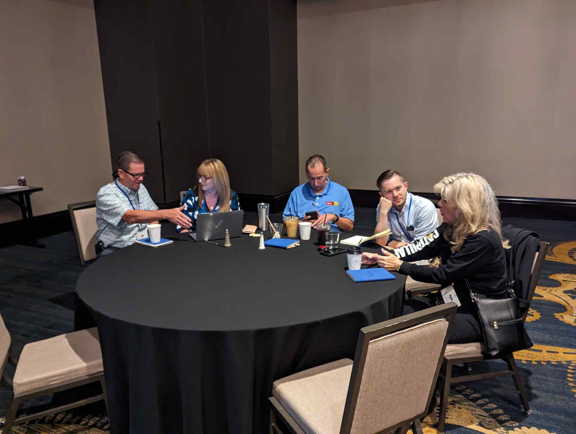 A group of individuals sitting around a table, engaged in a discussion