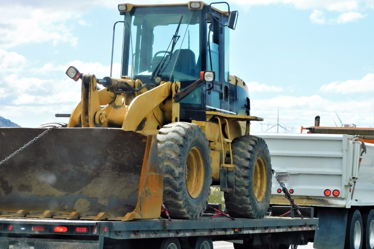 Bulldozer loaded on a trailer for highway transport using dispatching software